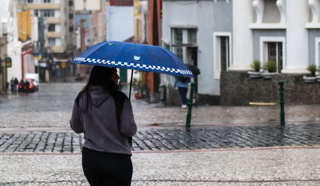 mulher segurando um guarda-chuva em Curitiba para ilustrar previsão do tempo
