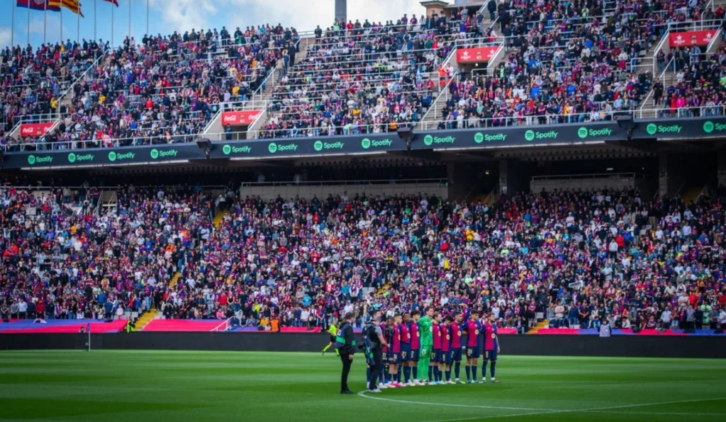 Time do Barcelona perfilado em campo com a torcida ao fundo