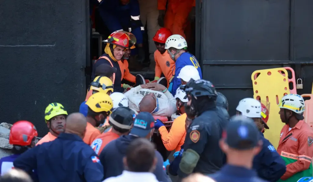 Imagem de socorristas salvando vítimas nos escombros.