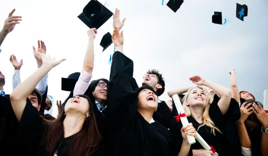 formandos universitários jogando o chapéu para cima