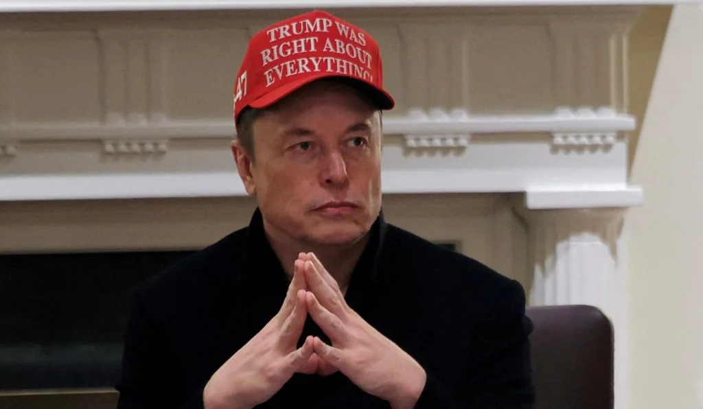 Elon Musk com boné vermelho.