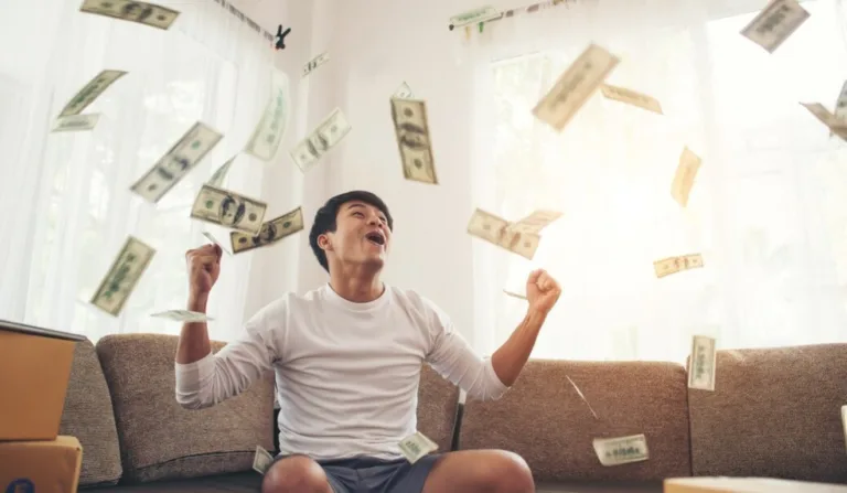 Homem comemorando sob chuva de dinheiro