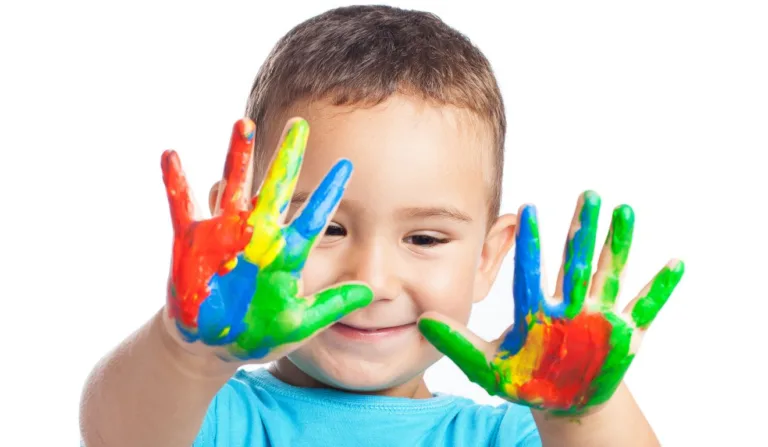 Criança com as mãos pintadas.