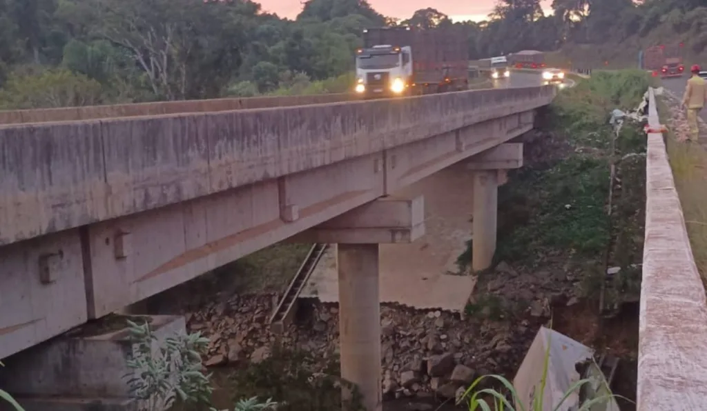 Caminhoneiro perdeu o controle em um trecho de curva e caiu em uma ribanceira, embaixo de uma ponte