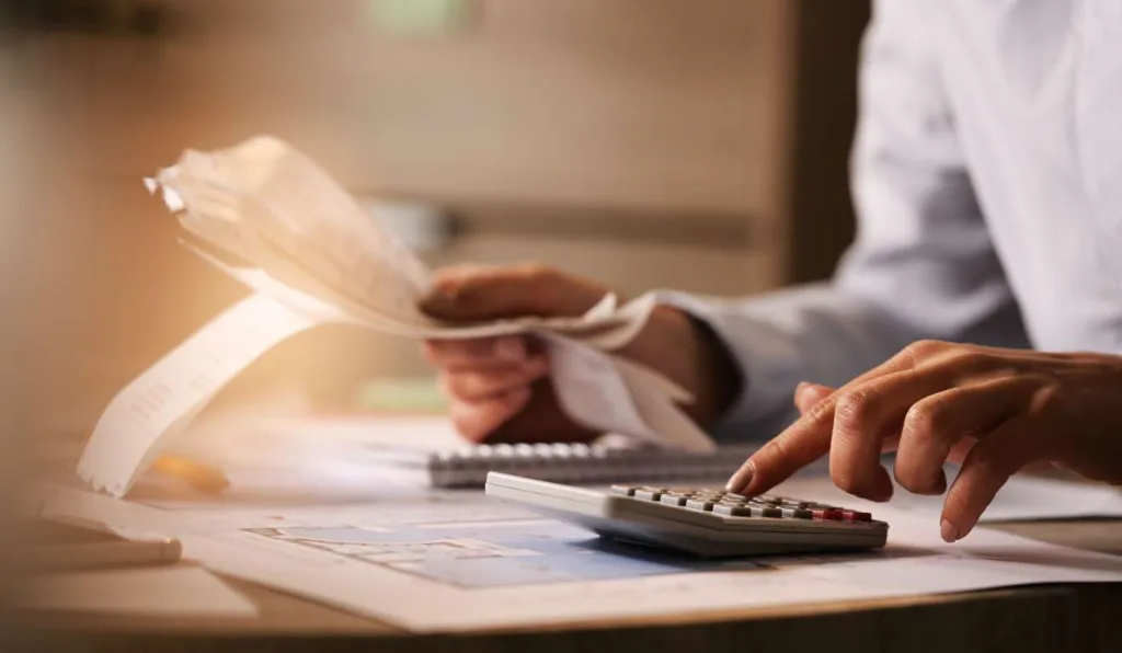 Mulher com calculadora na mesa