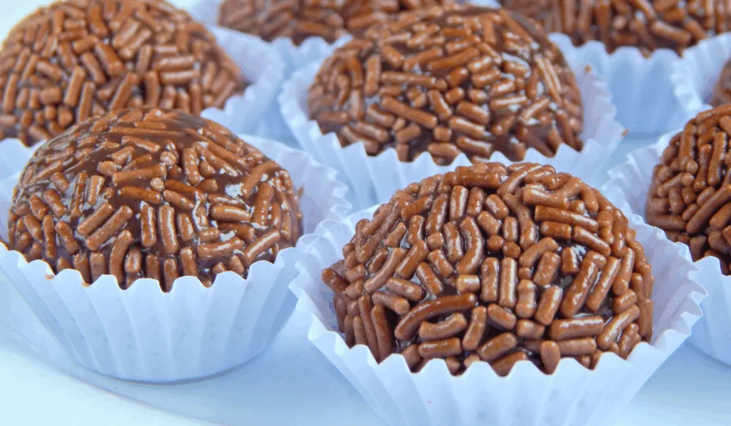 diversos brigadeiros de chocolate com forminhas brancas