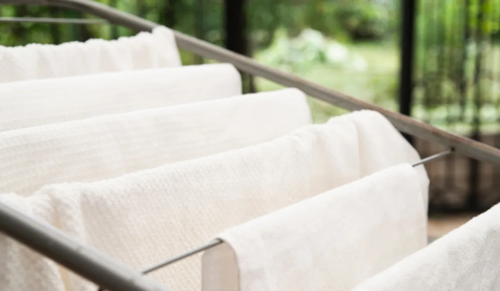 toalhas brancas em varal de chão em parte externa de casa 