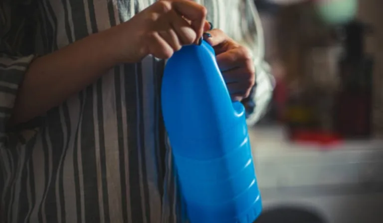 mulher segurando garrafa de água sanitária