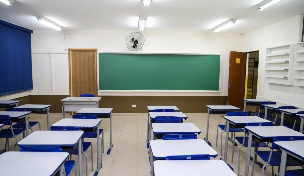 Sala de aula com carteiras e quadro negro