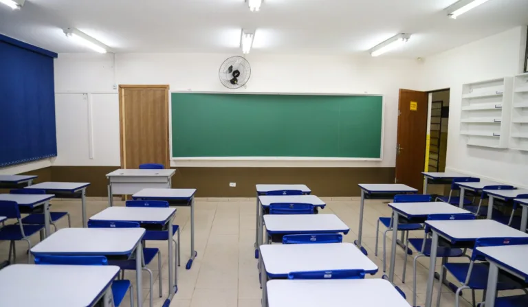 Sala de aula com carteiras e quadro negro