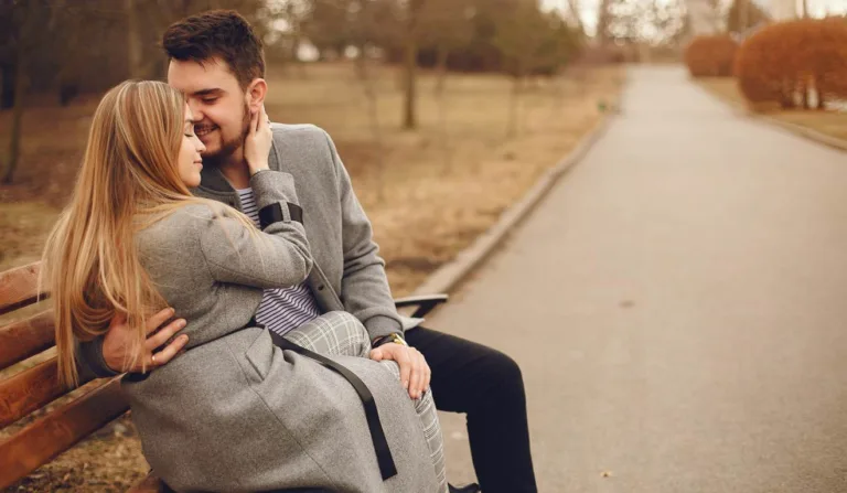 Casal se beijando em banco