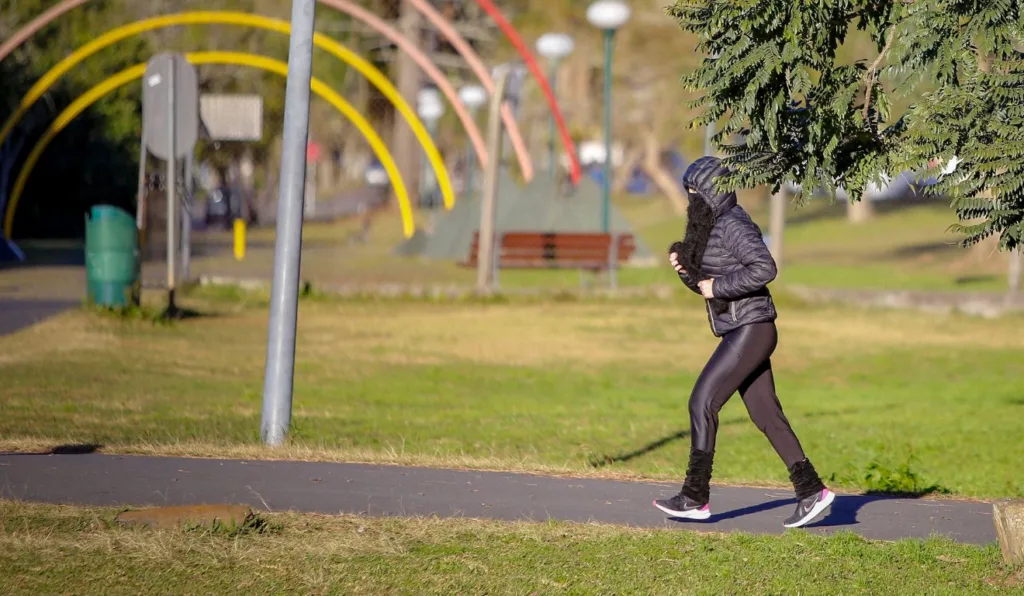 mulher correndo no sol mas com frio para ilustrar previsão do tempo no paraná