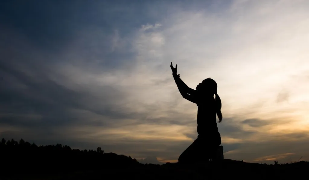 pessoa ajoelhada fazendo oração por cura