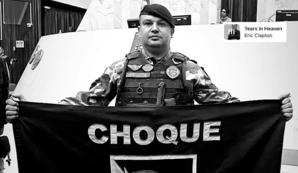 Policial Militar com bandeira da instituição