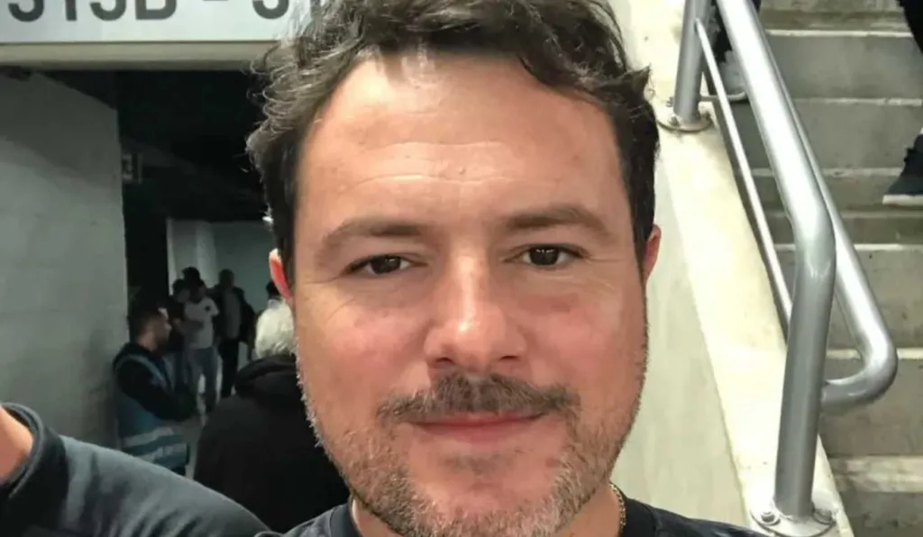 Homem sorrindo em estádio