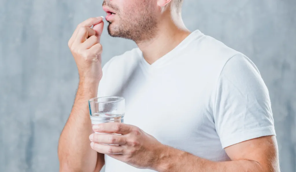 homem tomando remédio