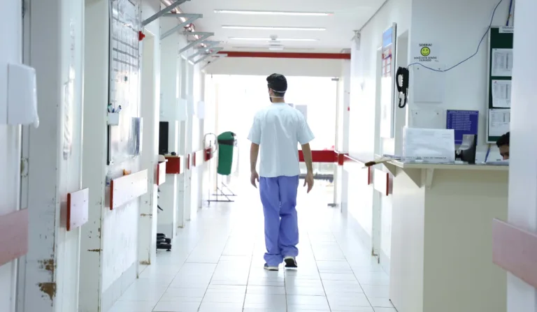 Profissional de saúde andando em corredor de hospital