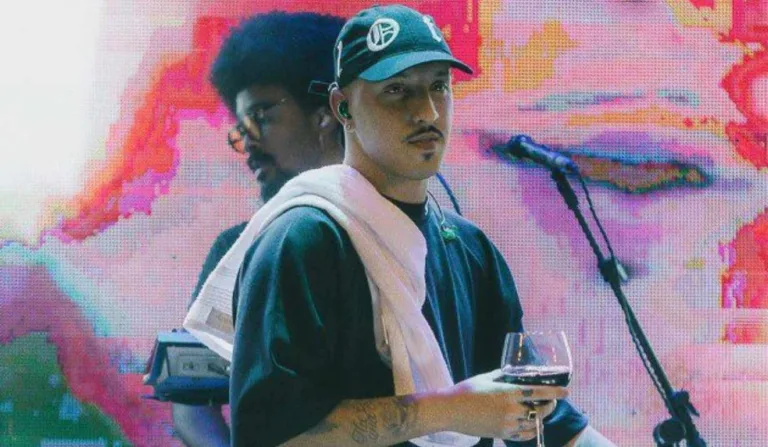 Delacruz com taça de vinho em palco.