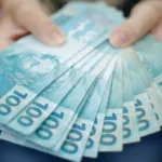 Pessoa segurando muitas notas de dinheiro