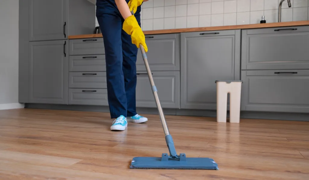 pessoa limpando piso com rôdo 