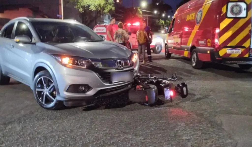 Motocicleta caída e carro batido após acidente