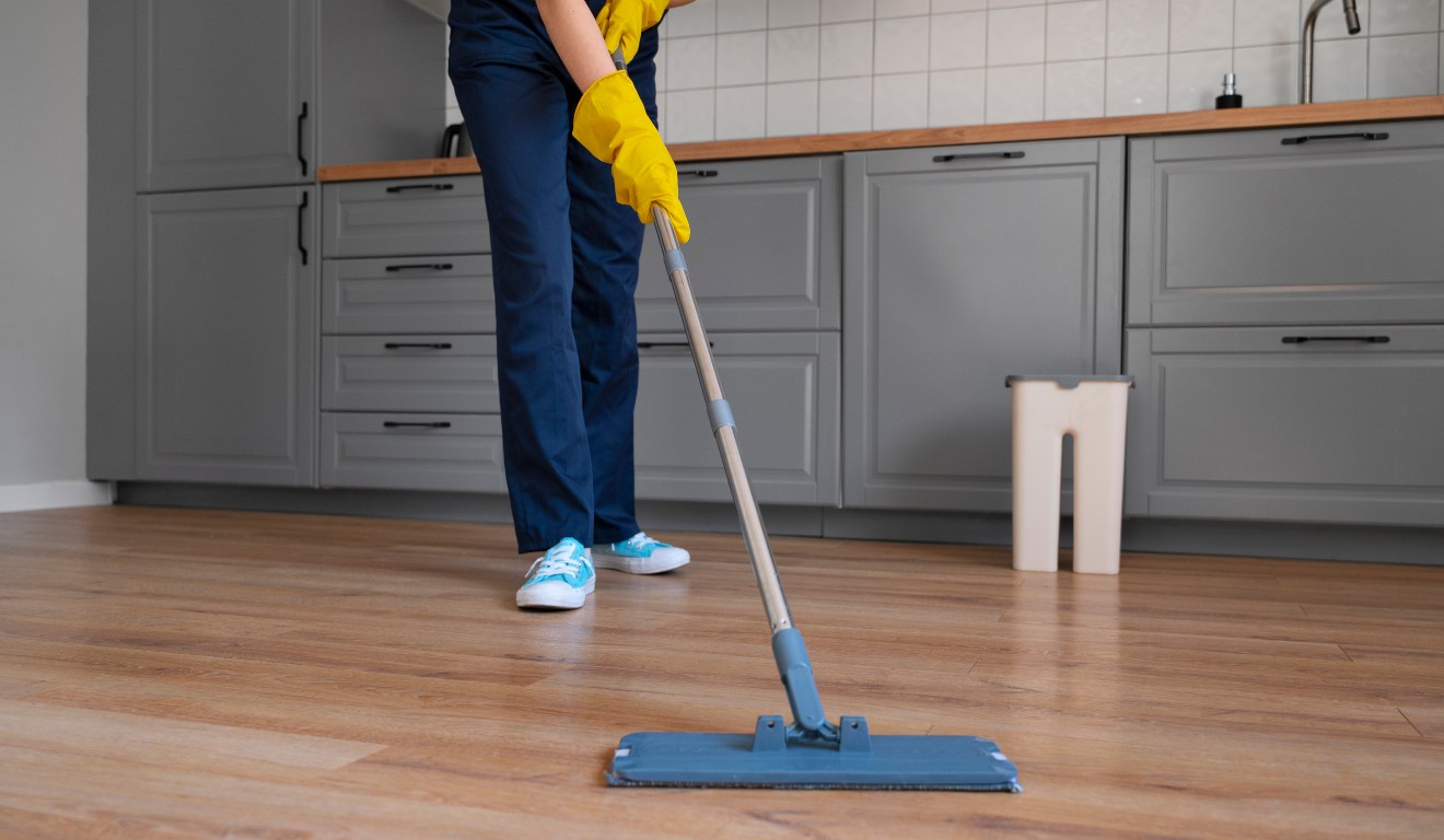 pessoa limpando piso com rôdo