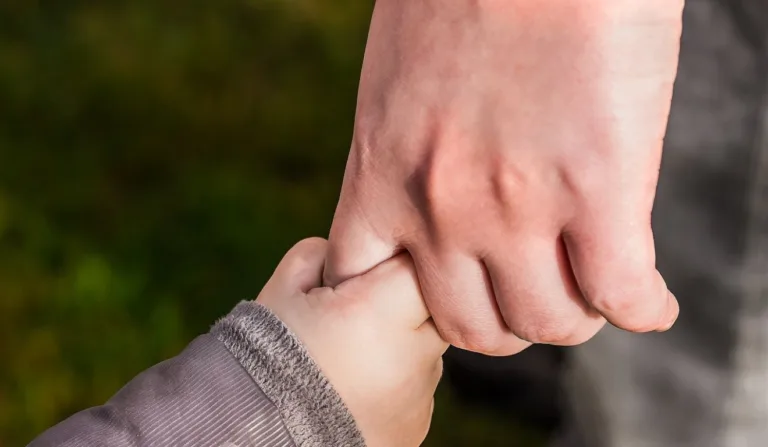 mãos segurando uma criança para ilustrar o caso do pai que levou a filha ao motel