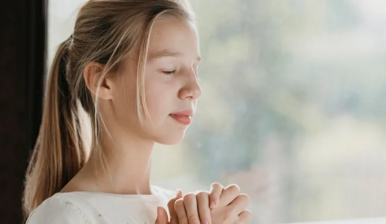 menina loira fazendo uma oração