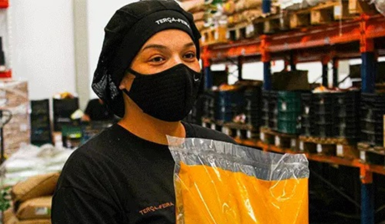 Mulher segurando saco de grãos