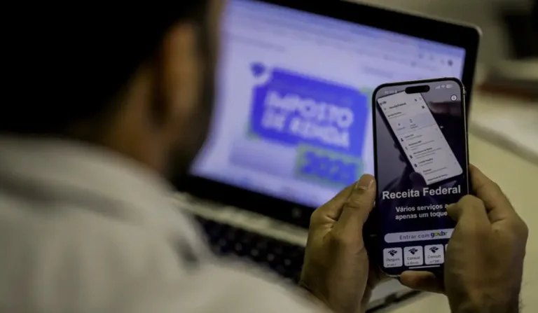 Homem conferindo a situação do Imposto de Renda no celular