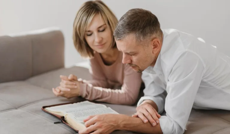 casal de meia idade lendo a bíblia e orando juntos