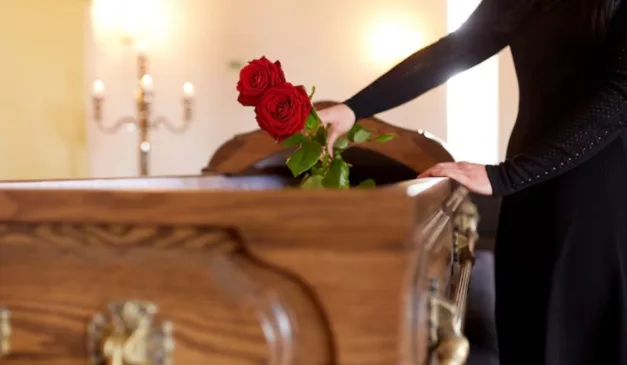 pessoa colocando rosas em caixão