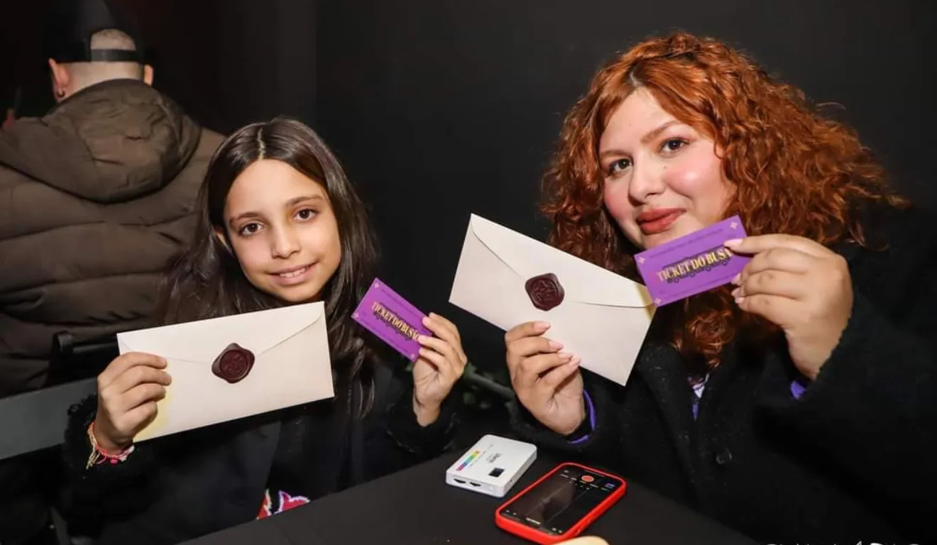 criança e mulher na Capi Potter segurando carta do evento