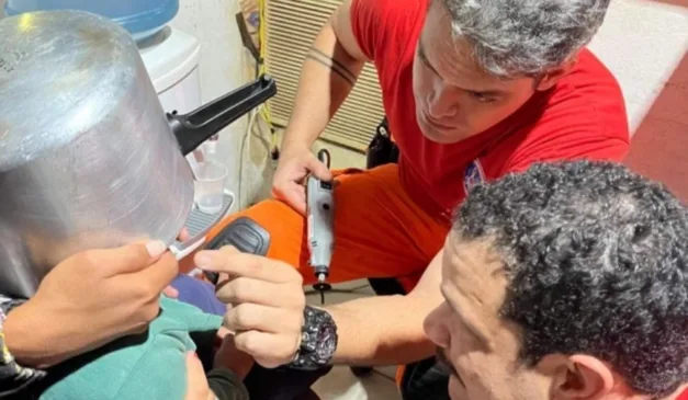 Bombeiros tirando panela de pressão da cabeça da criança
