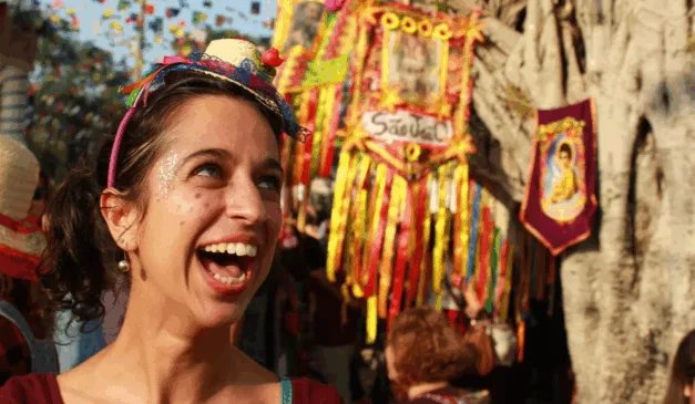 Imagem de uma mulher com chapéu sorrindo em uma festa junina.