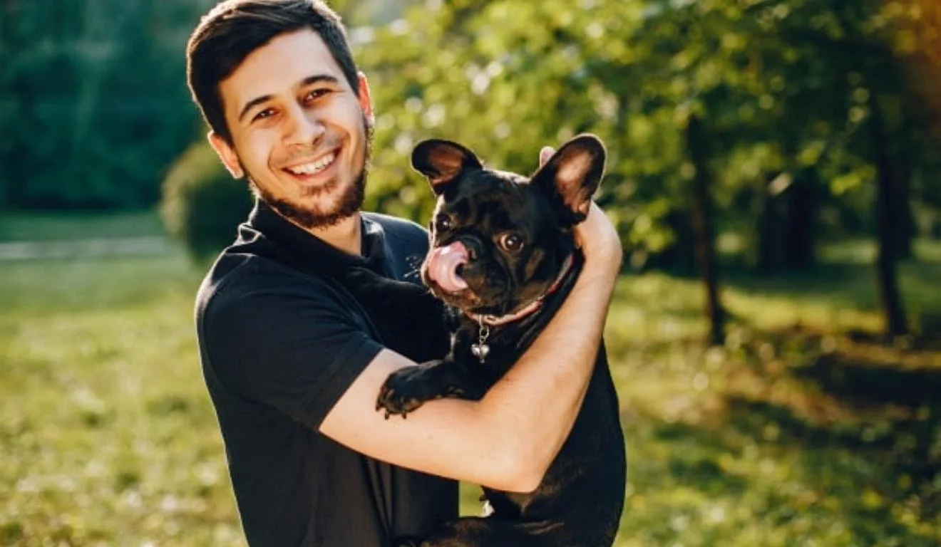 homem segurando buldogue francês