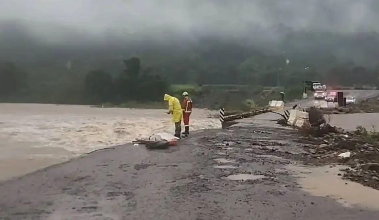 Pessoas em ponte destruída pelas enchentes no Rio Grande do Sul.