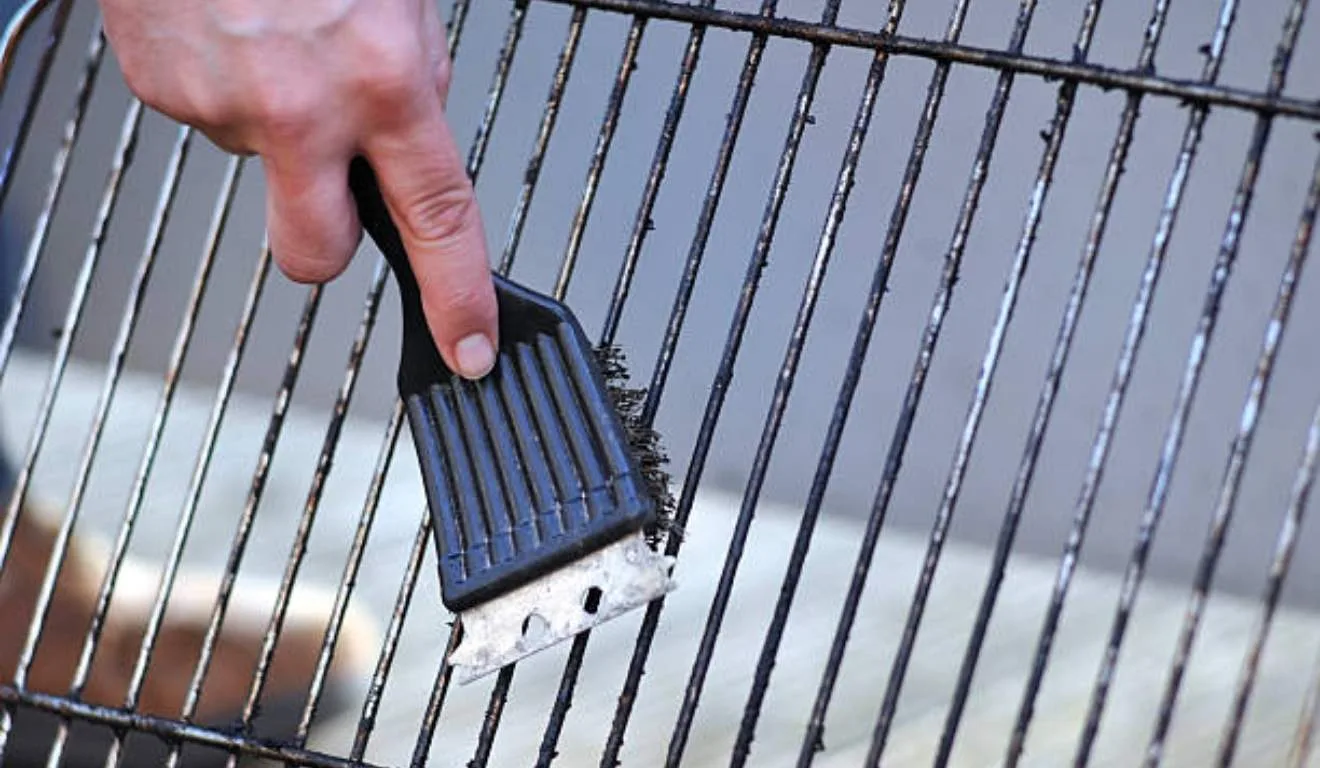 homem limpando grelha do churrasco