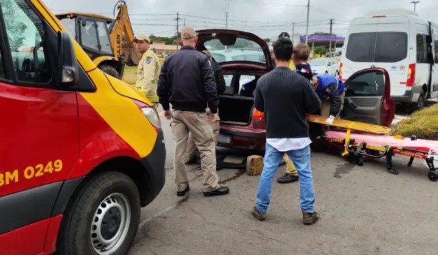 Socorristas do SIATE e populares observam resgate de homem que foi cuidar da mãe e sofreu acidente em rodovia de Curitiba