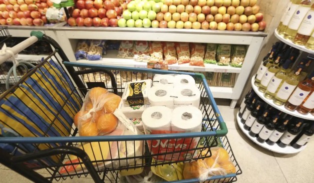 Carrinho de supermercado com itens básicos; inflação dos alimentos caiu no Brasil