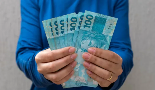 pessoa segurando notas de dinheiro