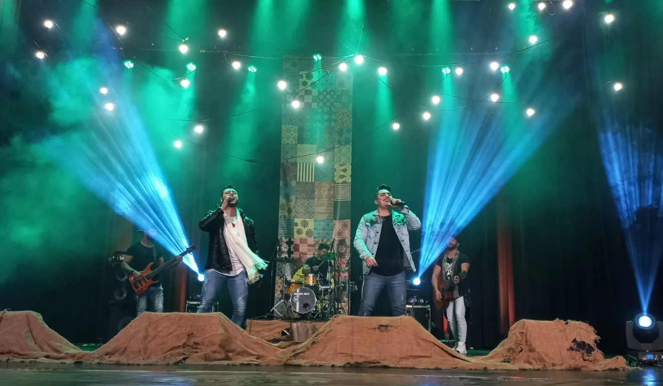 Imagem de dois homens cantando no festival.