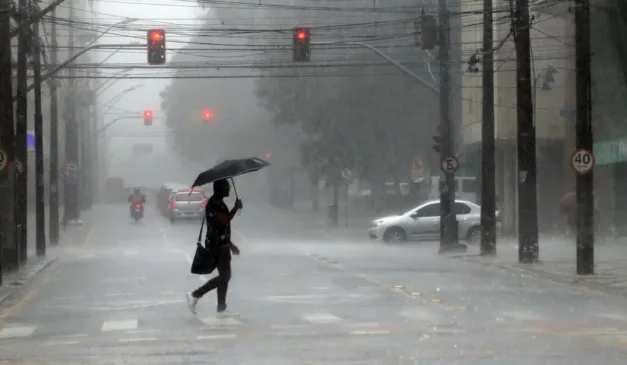 pessoas atravessando a rua enquanto chove