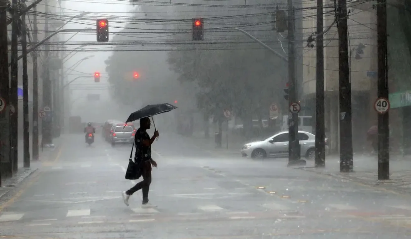 pessoas atravessando a rua enquanto chove