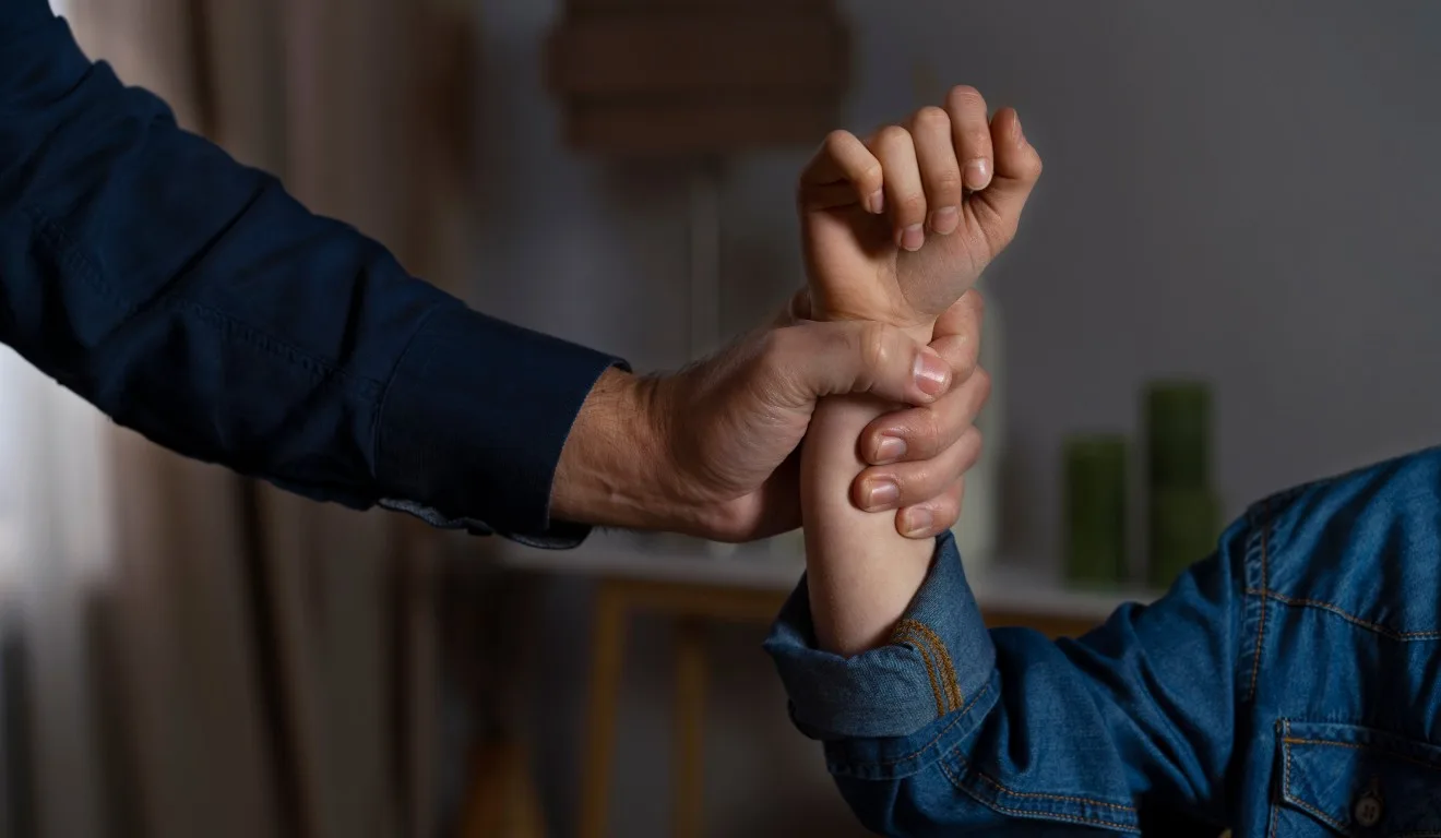 Homem segurando braço de criança