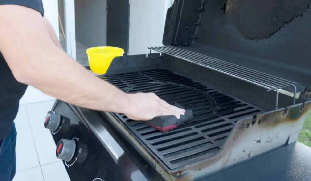 homem limpando grelha do churrasco