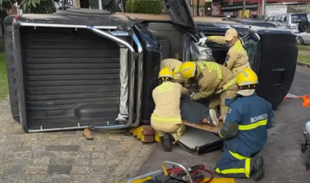 carro tombado com socorristas na frente