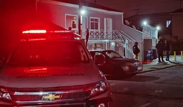viatura da PM em frente a uma pensão em que dois suspeitos morreram em confronto, em Colombo