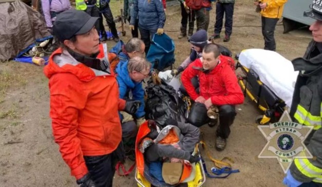 Socorristas carregando homem perdido em trilha.