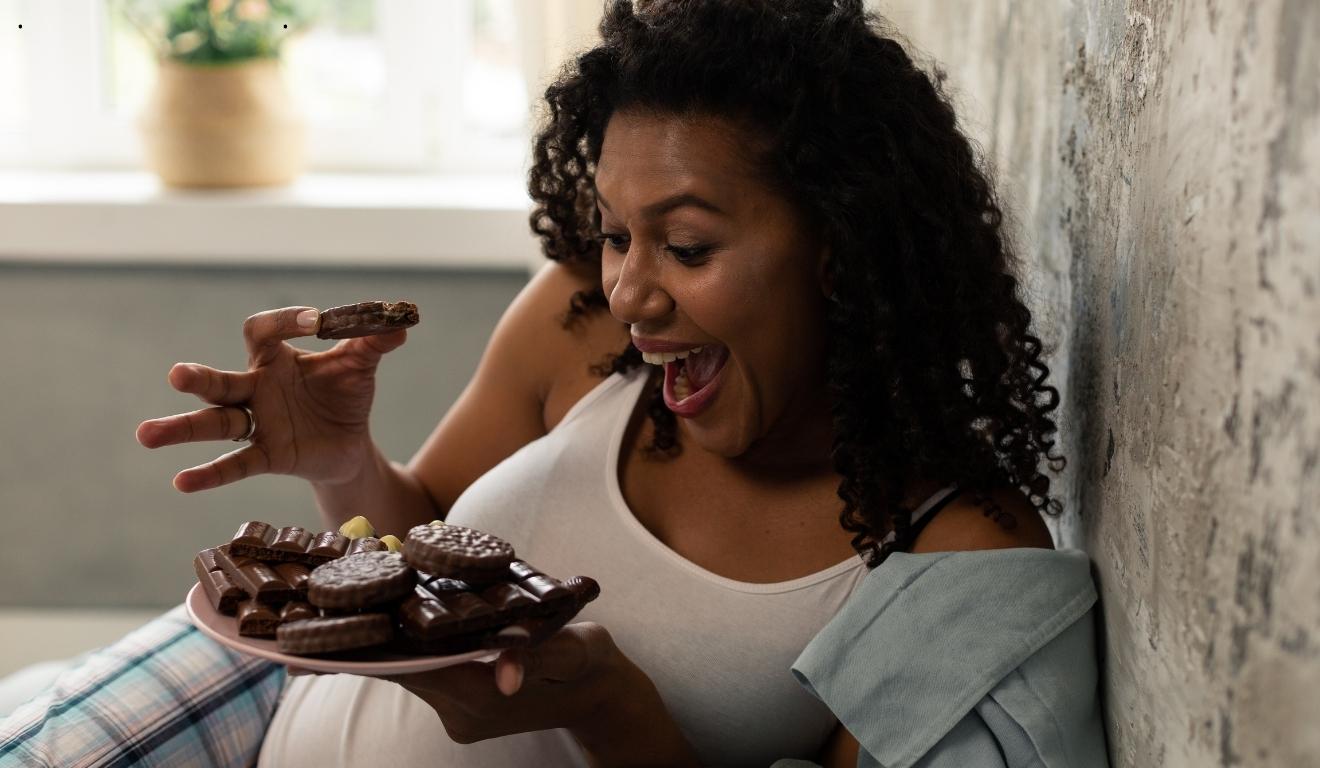 mulher comendo biscoitos e chocolate